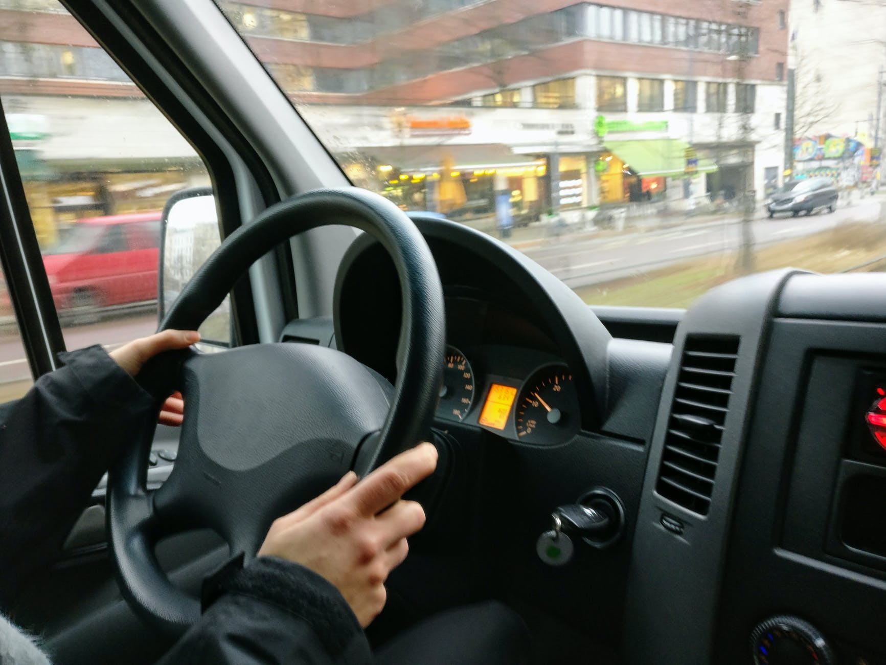 person holding steering wheel of car