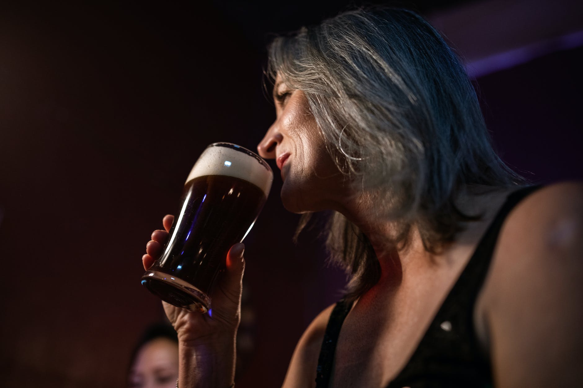 low angle photo of woman drinking a beer